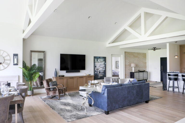 living room with white oak hard wood flooring blue couch and area rug facing flat screen tv