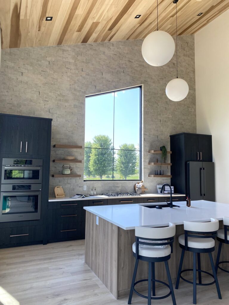 laminate wood look floor and high ceiling with wood planks and textured tile backsplash installed counter to ceiling