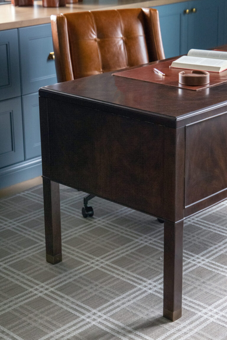 plaid wall to wall carpeting beige and white under a brown desk and leather chair