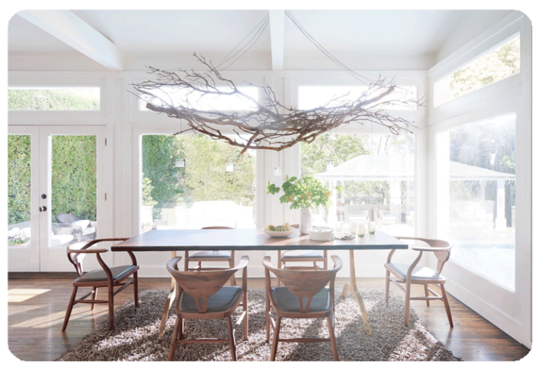sunny dining room with six chairs wall of windows and tree branch chandelier