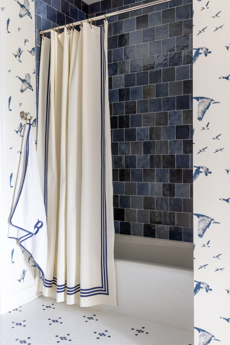 tub shower with textured blue tile shower wall