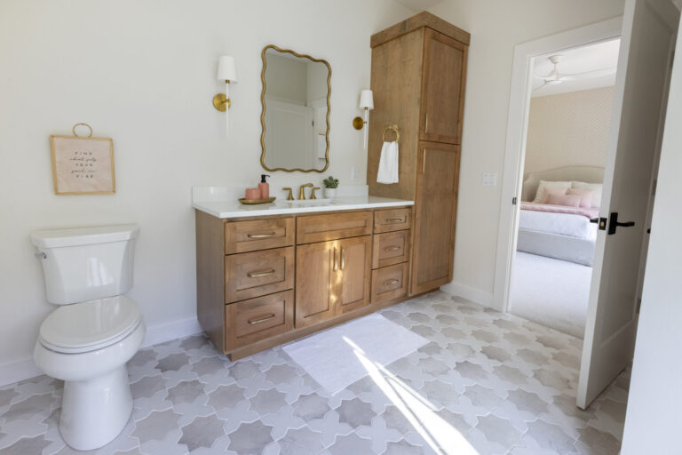 bathroom with marble floor that has geometric pattern wood vanity and attached linen closet