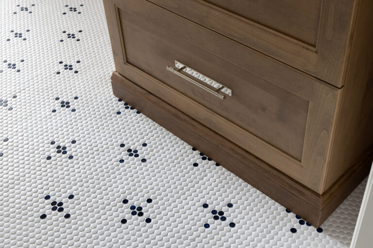 white penny round tile with cobalt blue cross pattern design in bathroom floor