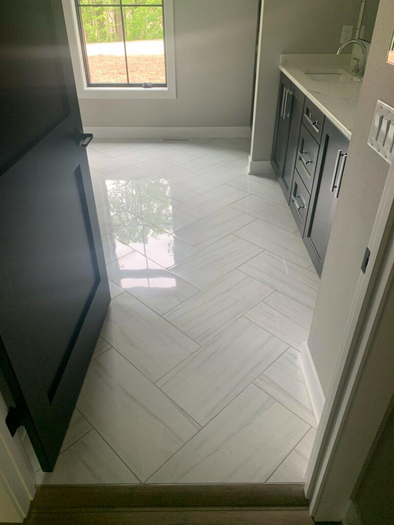 white marble tile floor herringbone installation