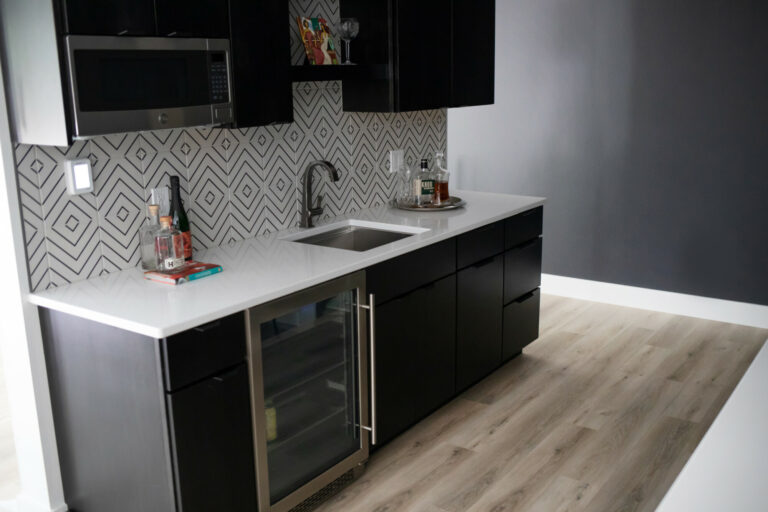 luxury vinyl plank floor with black linear backsplash tile