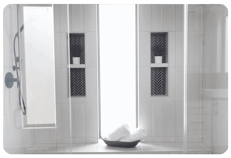 curbless walk in shower white tile black tile niche hexagon tile floor