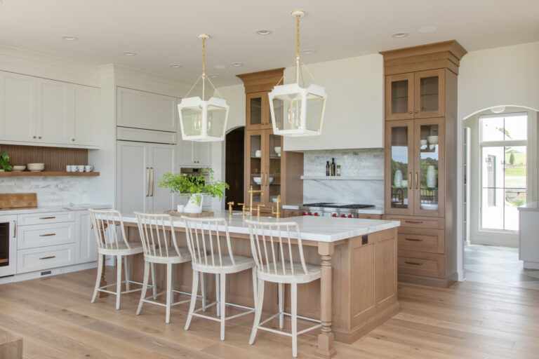 kitchen with hardwood floors wood and white cabinets and white tile backsplash with a wood cabinet island and white stools