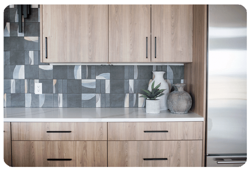 alternating patterns on graphite color art pottery style tile in a kitchen backpslash installed counter to ceiling