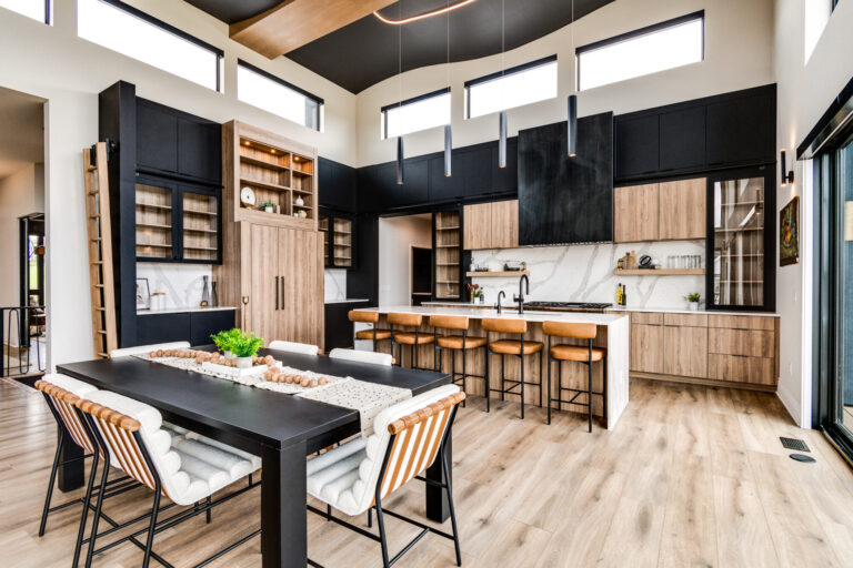 kitchen and dining table view of large room with luxury vinyl plank wood flooring and black and wood cabinetry
