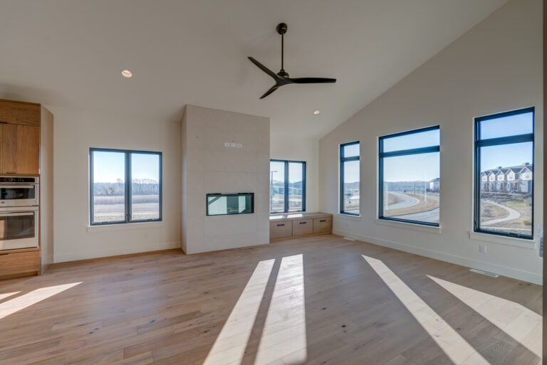 hardwood flooring no furniture with fireplace windows and ceiling fan