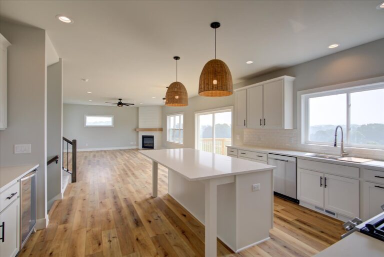View looking out from kitchen with luxury vinyl plank wood look floors white cabinets