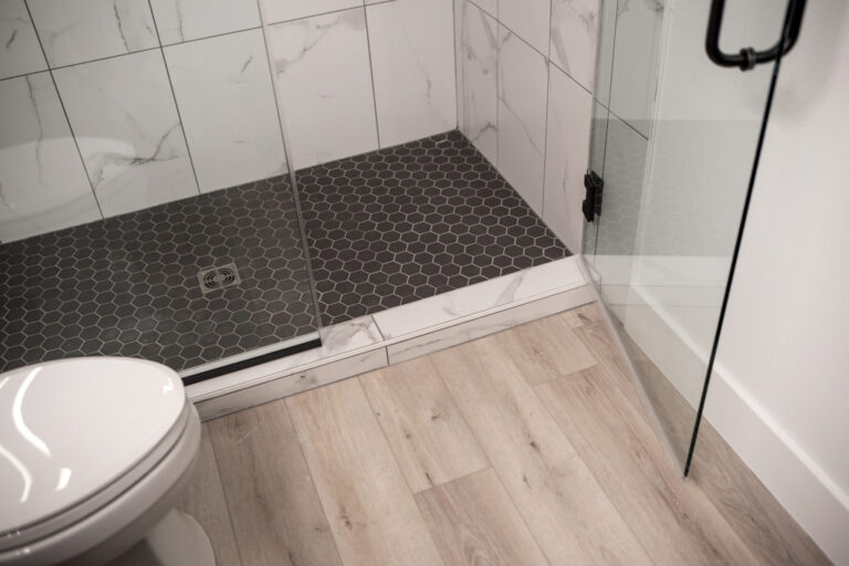 walkin shower with black tile floor glass enclosure and white tile wall