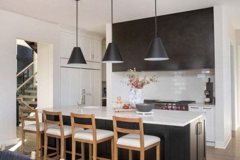 Kitchen view with hardwood flooring white tile backsplash with black cabinets