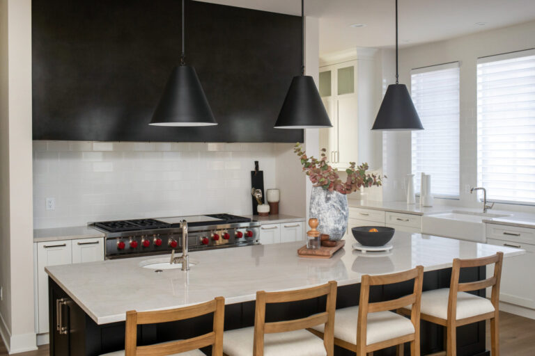 view of kitchen island white countertop and black cabinet with a white tile kitchen backsplash and black cabinets