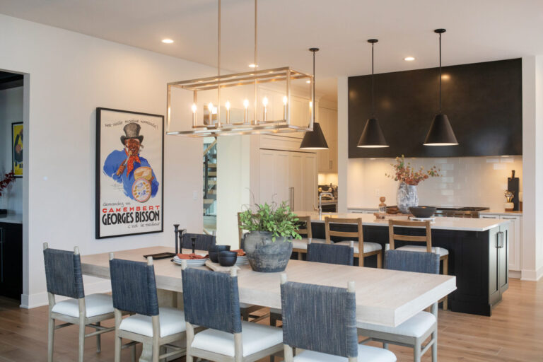 Kitchen view with white oak kitchen floors view dining room table, island and white kitchen tile backsplash with black cabinets