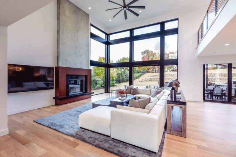 hardwood floor in a living room with a grey area rug and white couch