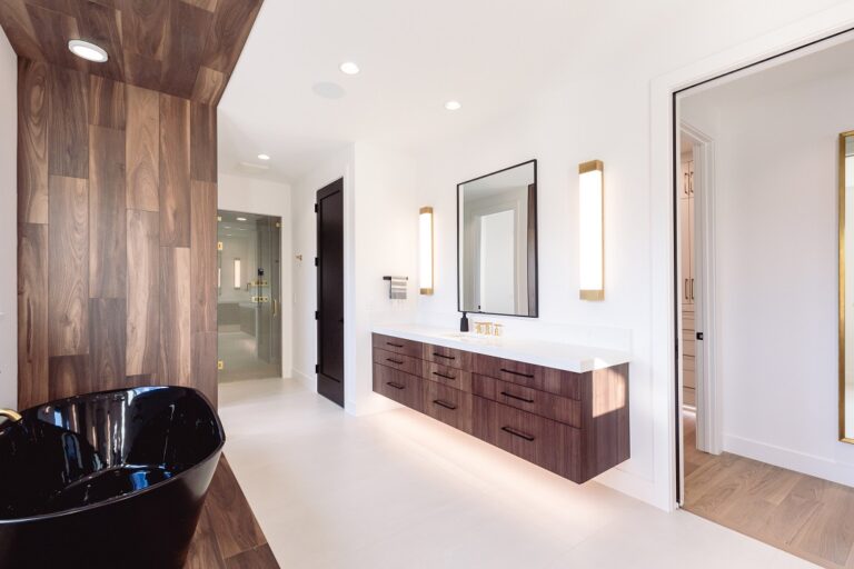 white primary bathroom with wood look tile surrounding a black free standing tub