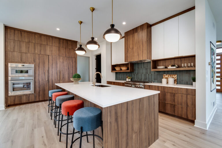 luxury vinyl plank wood look floor in kitchen with wood and cream color cabinet and a blue green tile backsplash
