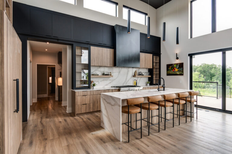 luxury vinyl plank wood look floors kitchen with island and four stools wood cabinets and black stove hood