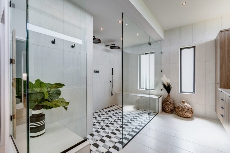 walk in curbless shower with have glass wall black and white tile floor and white tile wall