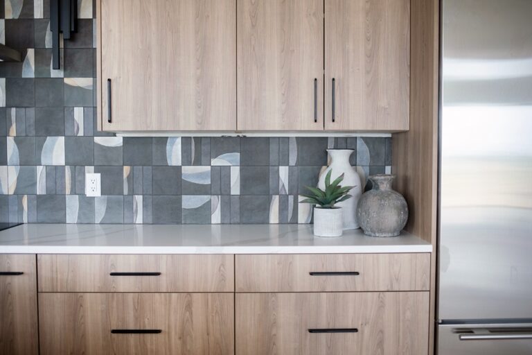 kitchen backsplash with grey tile that has alternating designs installed counter top to ceiling wood cabinets