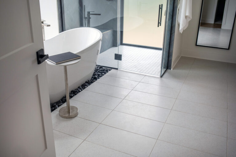 walk in curbless shower with large white tile bathroom floor and small white tile shower floor