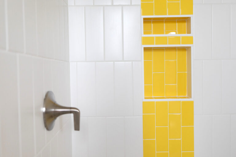 white tile shower wall with bright yellow tile stripe