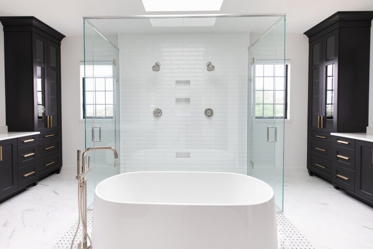 white tile bathroom with free standing tub and glass enclosed shower