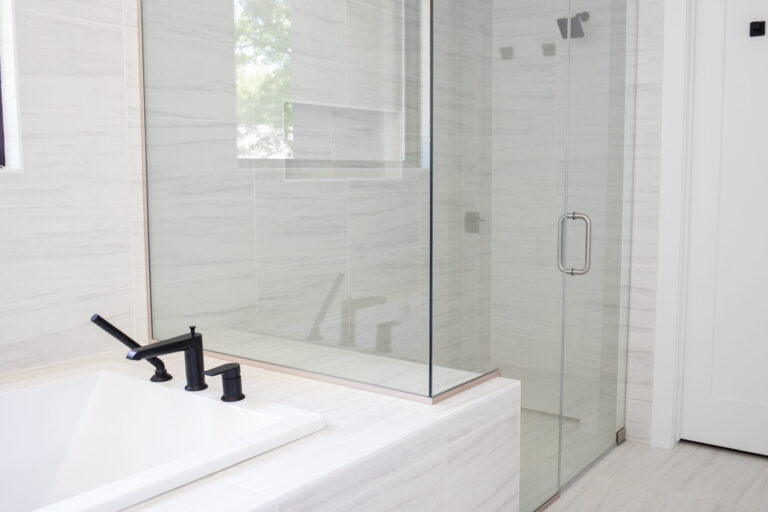 marble white tile bathroom with curbless walk in and floor