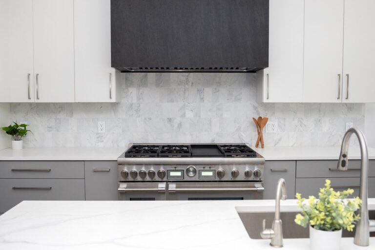kitchen backsplash with white marble tile black stove hood and white cabinets