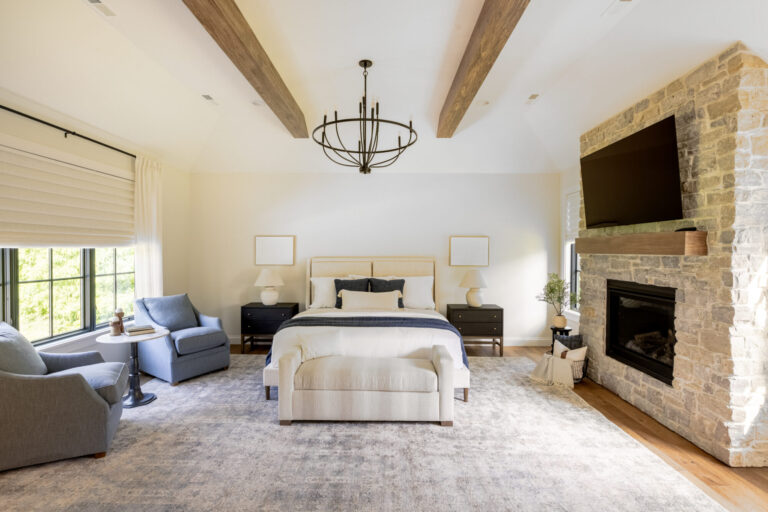bedroom with queen size bed large area rug on hardwood floor and wood beams on ceiling