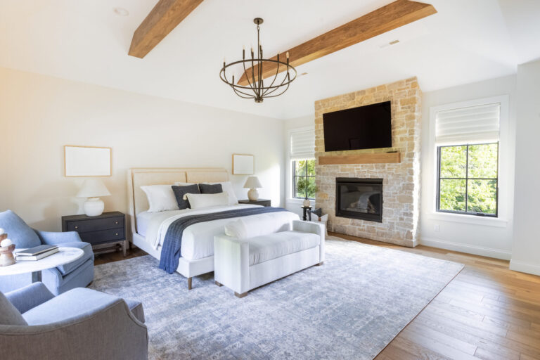 bedroom with large area rug queen size bed hardwood flooring wood beams on the ceiling