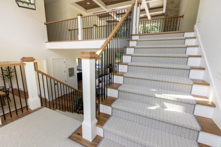 grey carpeting stair runner with white risers and hardwood steps