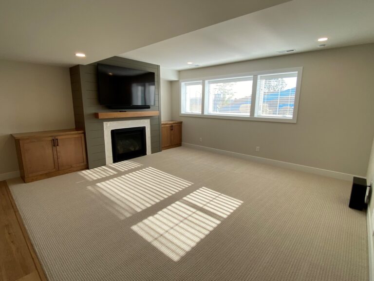 carpeting and fireplace with TV above in lower level