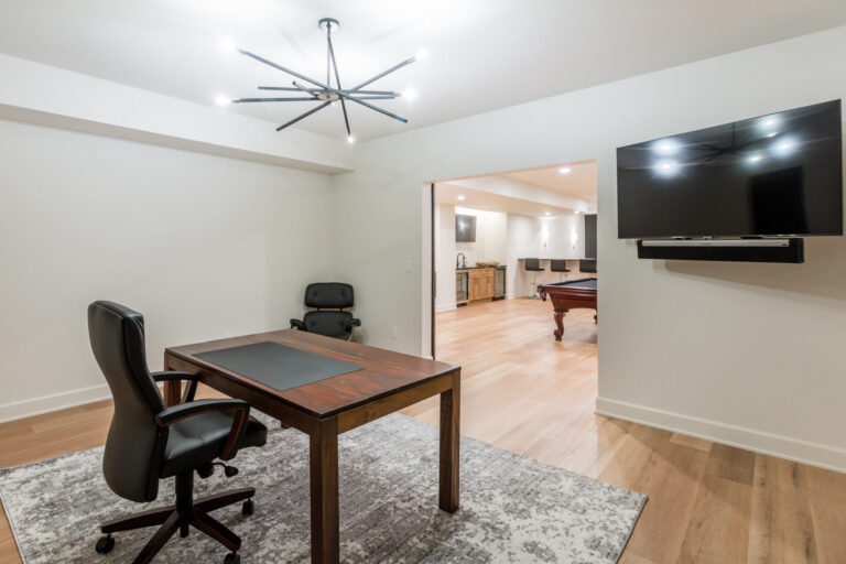 lower level home office with a table desk hardwood floor and area rug
