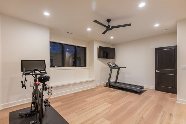 lower level fitness room with hardwood floor a treadmill