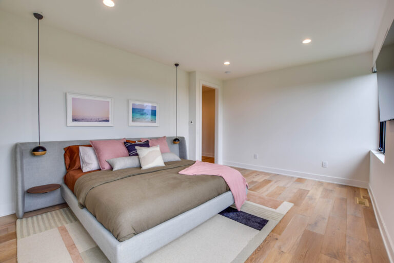 bedroom with white oak hardwood floor and a queen size bed with white painted walls
