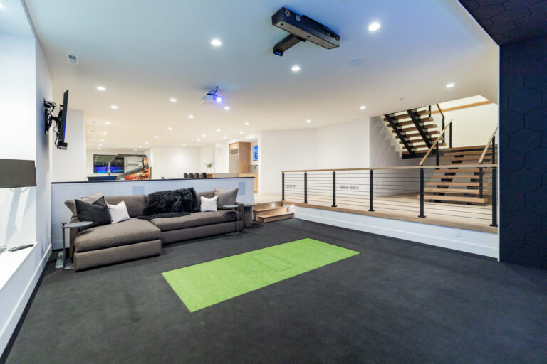 lower level indoor golf range with a couch and carpeting