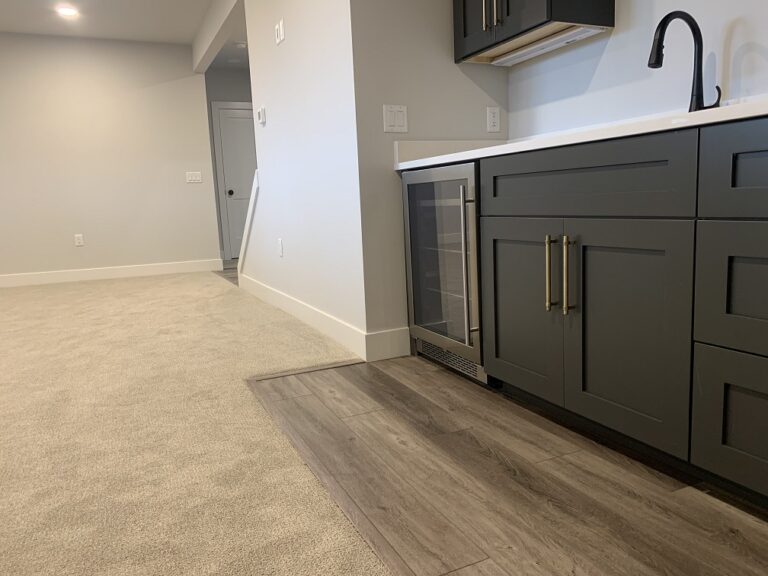 lower level floor view with wall to wall carpeting and luxury vinyl plank near the built in bar