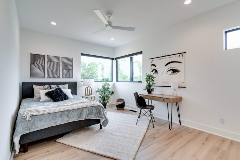 luxury vinyl plank wood look flooring in a bedroom with queen size bed in the corner and white paint walls