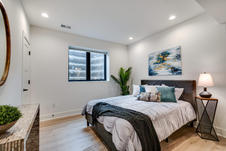 luxury vinyl plank wood look floor and queen size bed in a bedroom with white paint walls