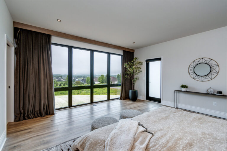 bedroom with luxury vinyl plank flooring floor to ceiling windows and edge of queen size bed
