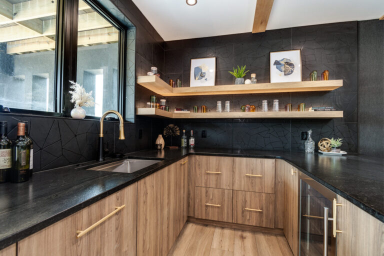 lower level bar area with black tile backsplash and wood look luxury vinyl plank