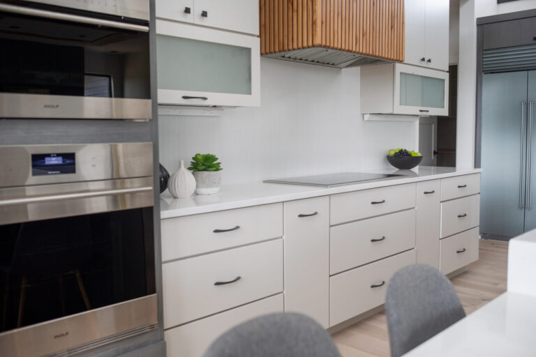 kitchen with white cabinets white tile backsplash and white oak hardwood flooring
