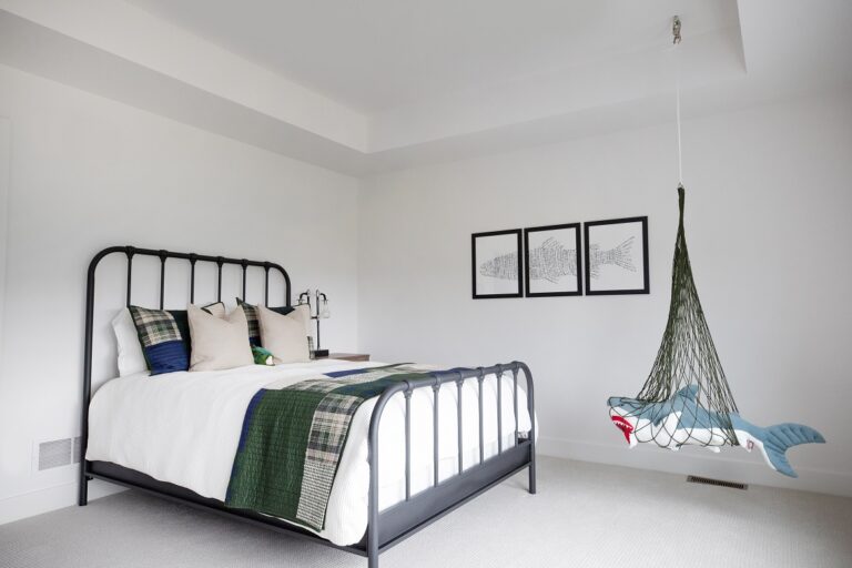 bedroom with queen size bed and black metal head board with grey wall to wall carpeting