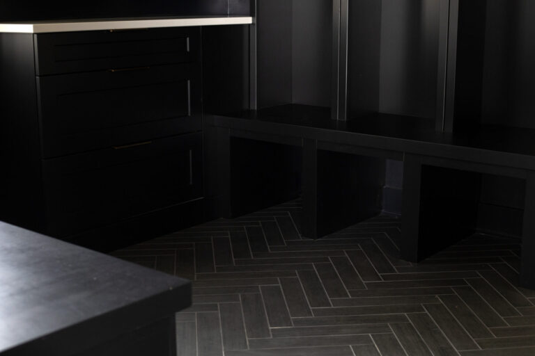 dark grey tile installed herringbone pattern in mud room