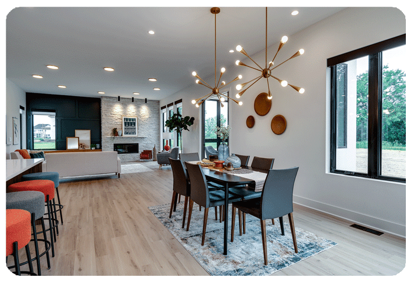 view of a dining table in a large great room with a sofa and fireplace on opposite wall the flooring is light white oak luxury vinyl plank look