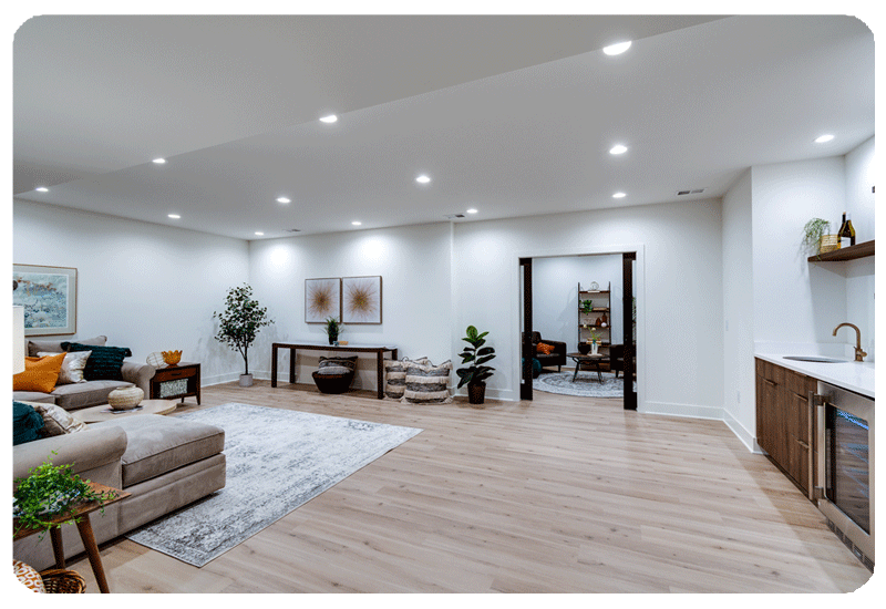 view in a lower level light white oak color luxury vinyl plank floor with partial area rug visible and tan sofa