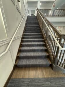 grey and white pattern carpet on large stairs leading from lobby to second floor inside Westerly Pewaukee WI