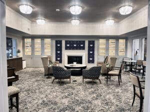 view of a sitting room a seating arrangement facing a fireplace with a floral pattern carpet tile floor